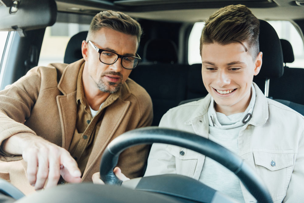 Young male teen in the car with driving instructor